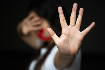 Woman hand sign for stop and wrapping her mount, abusing violence. Human Rights Day concept.
