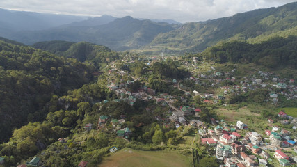 Fototapeta na wymiar Aerial view town of Sagada, located in the mountainous province of Philippines. City in the valley among the mountains covered with forest. Sagada-Cordllera region-Luzon island.