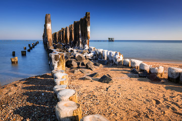Fototapeta premium Frozen wooden breakwaters line at Baltic Sea, Babie Doly, Poland