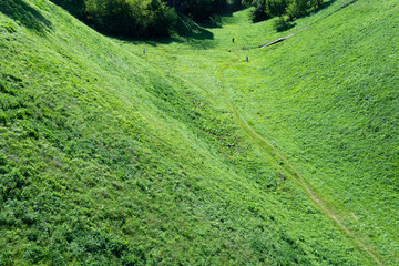 Top view of the hollow between the mountains and people walking.