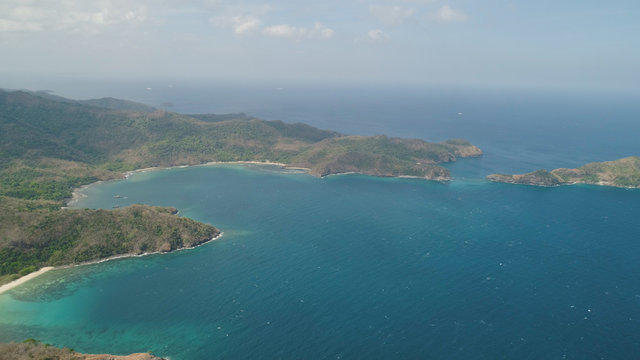 Aerial view of coast with beaches, island Limbones, lagoons and coral reefs. Neela cove, Philippines, Luzon. Coast ocean with turquoise water. Tropical landscape in Asia.