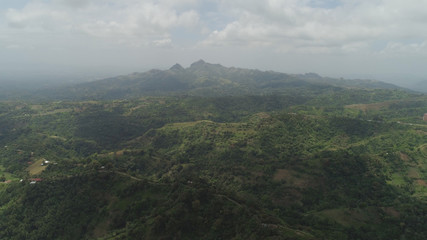 Aerial view of mountains covered forest, trees. Cordillera region. Luzon, Philippines. Slopes of mountains with evergreen vegetation. Mountainous tropical landscape.