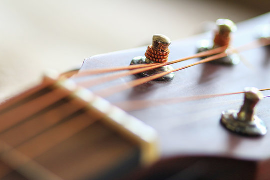 Close up of an acoustic guitar in a wheat field