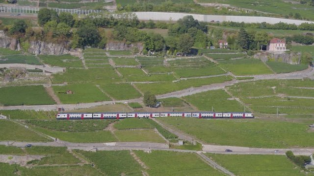 Aerial shot following Swiss through Lavaux vineyard and entering Chexbres village, Switzerland