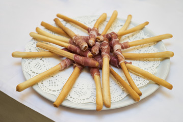 Bread sticks with a prosciutto, delicious food catering, wine sn