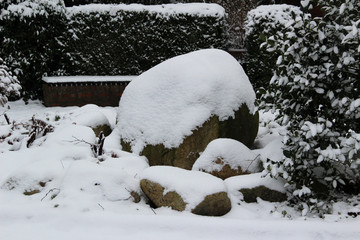 schneebedeckter findling in einem park im emsland niedersachsen deutschland fotografiert während...