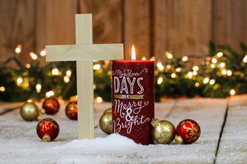 Holiday candle with wood cross and Christmas decorations