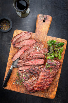 Traditional American Barbecue Dry Aged Flank Steak Sliced As Top View On An Old Board