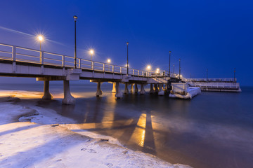 Obraz premium Snowy night at the Baltic Sea pier in Gdansk, Poland