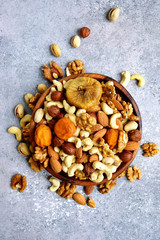 Wooden bowl with nuts ( pistachio, walnut, hazelnut, cashew, almond)  and dried fruits.Top view with copy space.