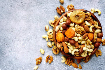 Wooden bowl with nuts ( pistachio, walnut, hazelnut, cashew, almond)  and dried fruits.Top view with copy space.