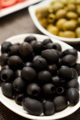 Assortment of fresh olives on a plate, close-up. Healthy snack f