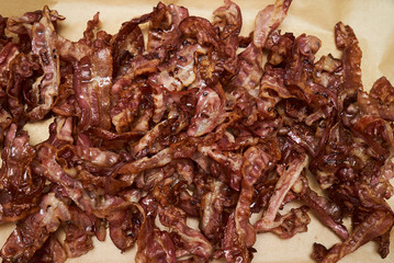 Hot fried bacon pieces background, close-up. Freshly