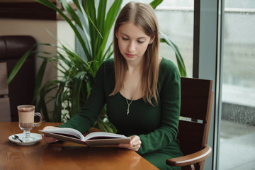 Woman reading book in the cafe