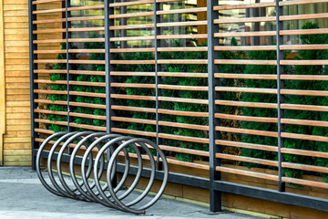 Empty public bicycle parking side view, a place near the gazebo decorated with planks.