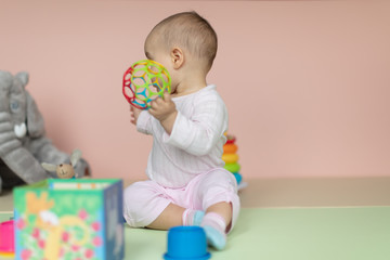 Fototapeta na wymiar Baby girl playing with various toys