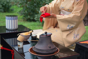 Woman in kimono performs Japanese tea ceremony