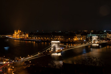 Fototapeta na wymiar Budapest, Ungarn., Kettenbrücke über die Donau, im Hintergrund das monumentale Parlamentsgebäude bei Nacht mit Beleuchtung neben der Donau