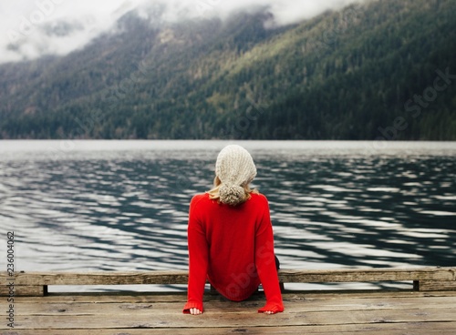 Rear view of woman sitting on pier