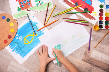 Little girl drawing with color pencils on floor