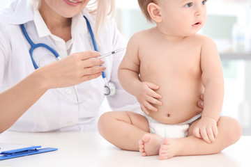 Naklejka premium Female doctor vaccinating baby boy in clinic