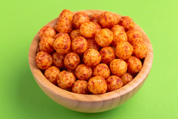 Bacon puff balls in wooden bowl on bright colorful background