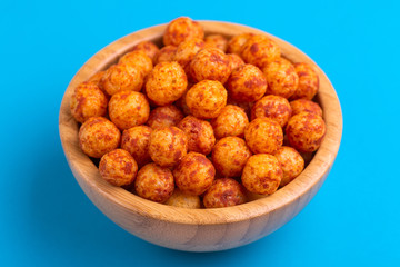 Bacon puff balls in wooden bowl on bright colorful background