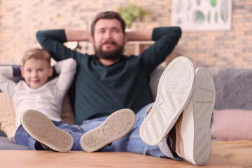 Father and son watching TV together at home