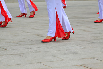 White trousers and red shoes
