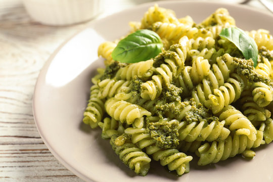 Fototapeta Plate with delicious basil pesto pasta on table