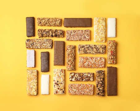 Flat lay composition with protein bars on color background