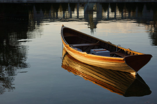 Empty rowboat on water with reflection