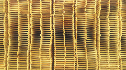a lot of yellow pallets standing on each other in a row in several columns
