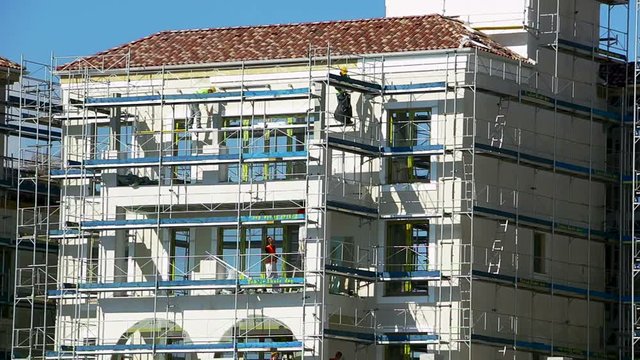 Workers Are Working On An Adaptation Of The Wall Facade Of A Luxury Building