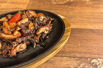 Grilled octopus with black skillet vegetables