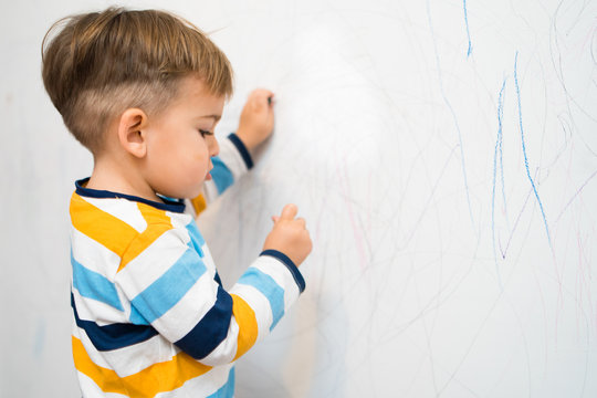 Baby Boy Drawing on the White Wall 