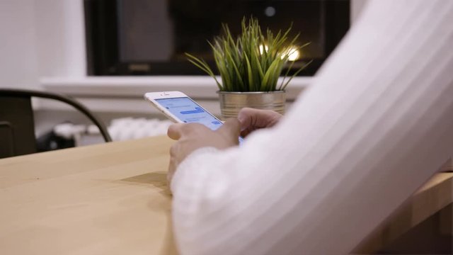 Side View of Young Person Texting Friends on a Touchscreen Smartphone
