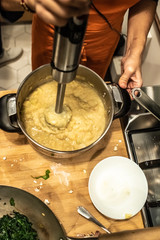Valencia, Spain - November 9, 2018: Woman using a blender during the preparation of a vegan dish in a cooking course.