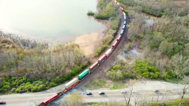 Skyview over top a cargo train crossing the highway
