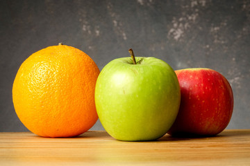 An orange and apples over grunge black background