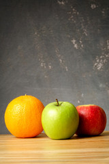 An orange and apples over grunge black background
