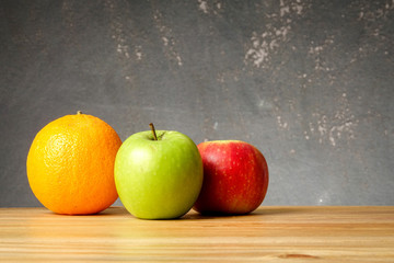 An orange and apples over grunge black background