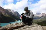Hiker man sitting on rock with dog