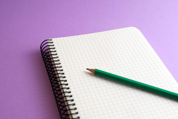 spiral book with green pencil purple background. business concept