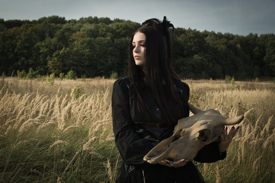 Gothic girl next to the skull of a cow