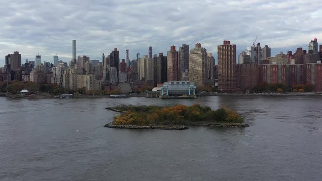 Drone circling Mill Rock Island in the East River of NYC.  Nice skyline view of the Upper East Side.  in 4K.