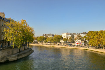 Fototapeta na wymiar View from the Pont of Sully of the banks of the Seine River with people and autumn trees