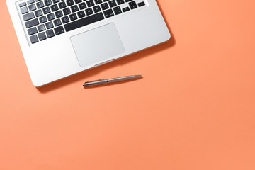 Office desk with white laptop, notebook, pen on table. Workspace. Top view of table with clear space for text.