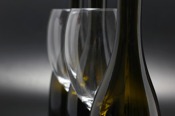 Three wine bottles and two empty wine glasses close up