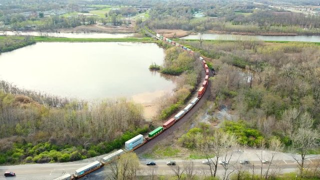 Skyview of a cargo train crossing through traffic